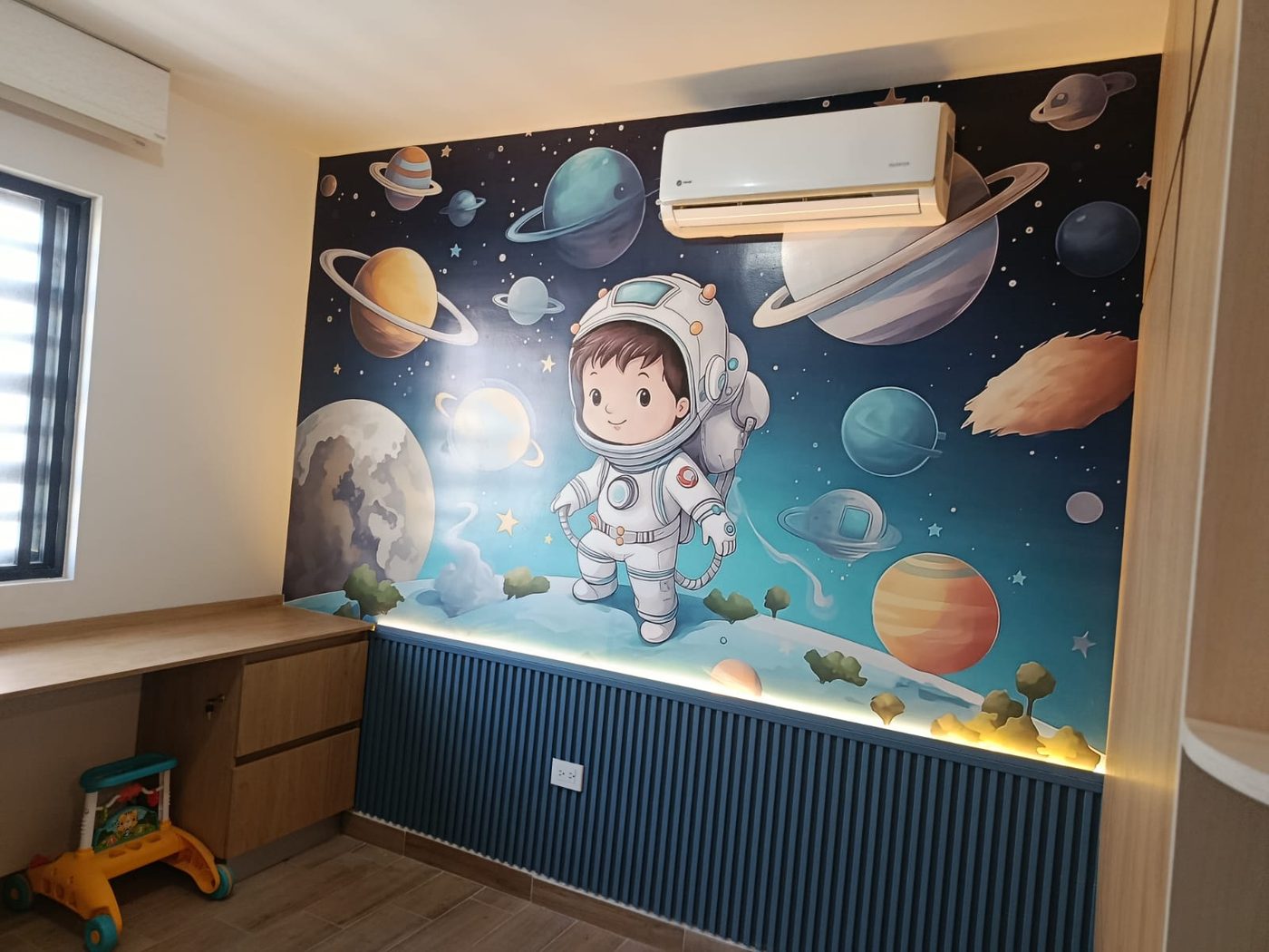Mural decorativo infantil con vinil impreso gran formato de astronauta y planetas instalado por Punto Clave en habitación de bebé en Monterrey