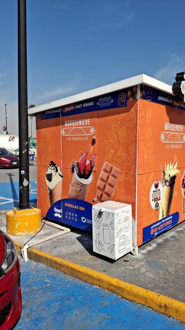 Quiosco completo de helados Marquenieve rotulado con vinil impreso de gran formato cubriendo toda su estructura con productos y branding instalado por Punto Clave en Monterrey