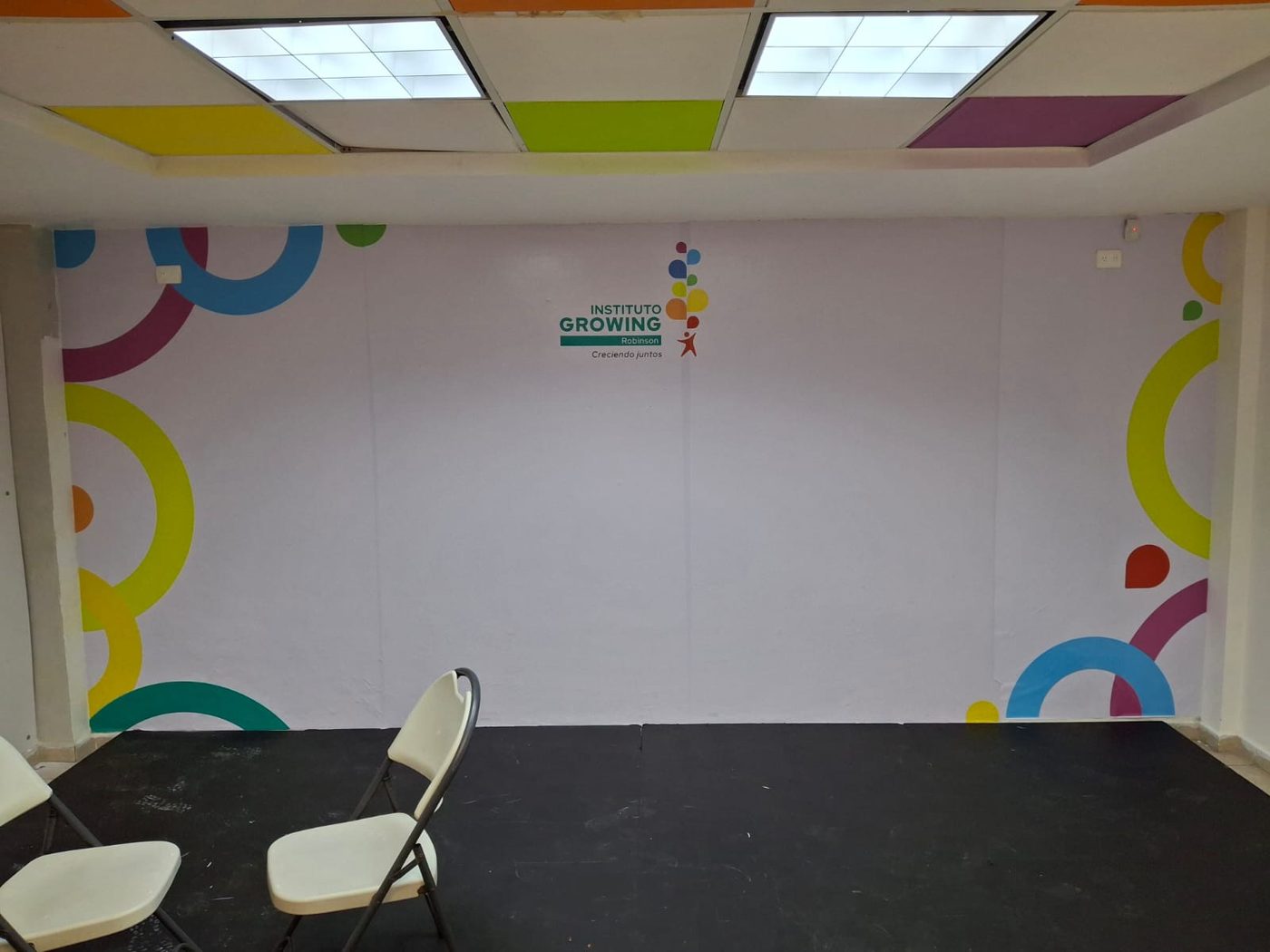 Mural de aula educativa con composición de círculos de colores y logotipo del Instituto Growing Robinson instalado por Punto Clave