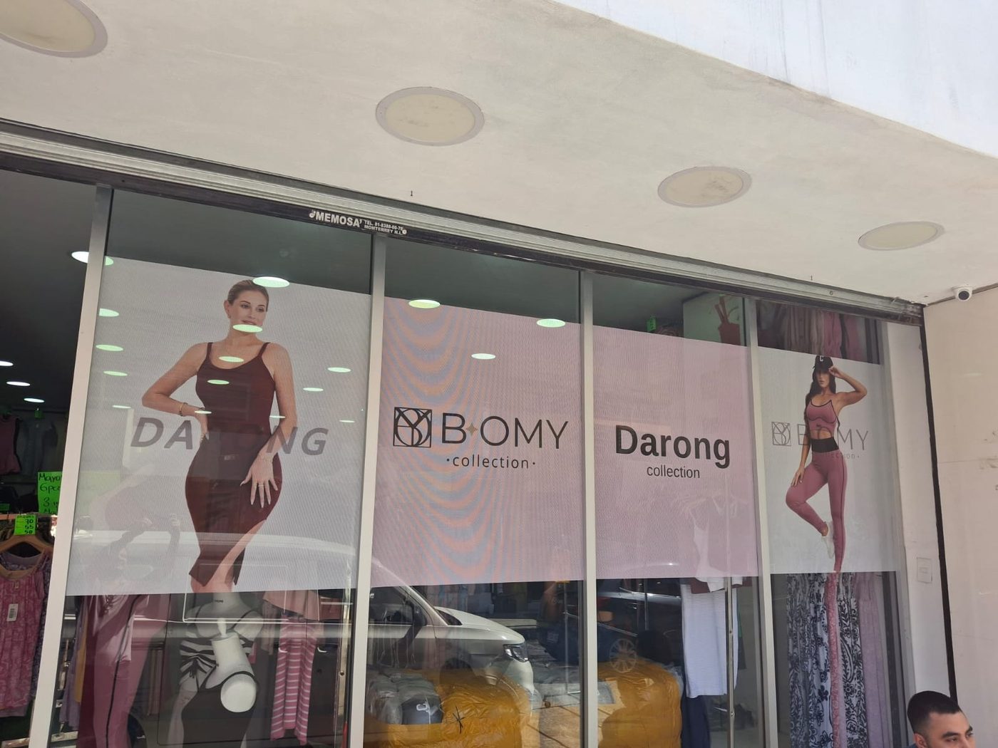 Rotulación de vidriera de boutique de ropa con fotografías de modelos en vinil microperforado y logotipos de las colecciones Bomy y Darong instalada por Punto Clave en Monterrey