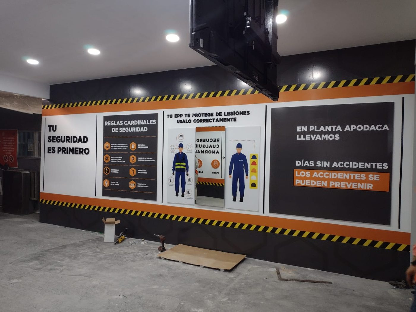 Pared de comunicación industrial con paneles 'Tu seguridad es primero', 'Reglas Cardinales de Seguridad', 'Tu EPP te protege de lesiones' y contador de días sin accidentes para planta corporativa en Apodaca instalada por Punto Clave