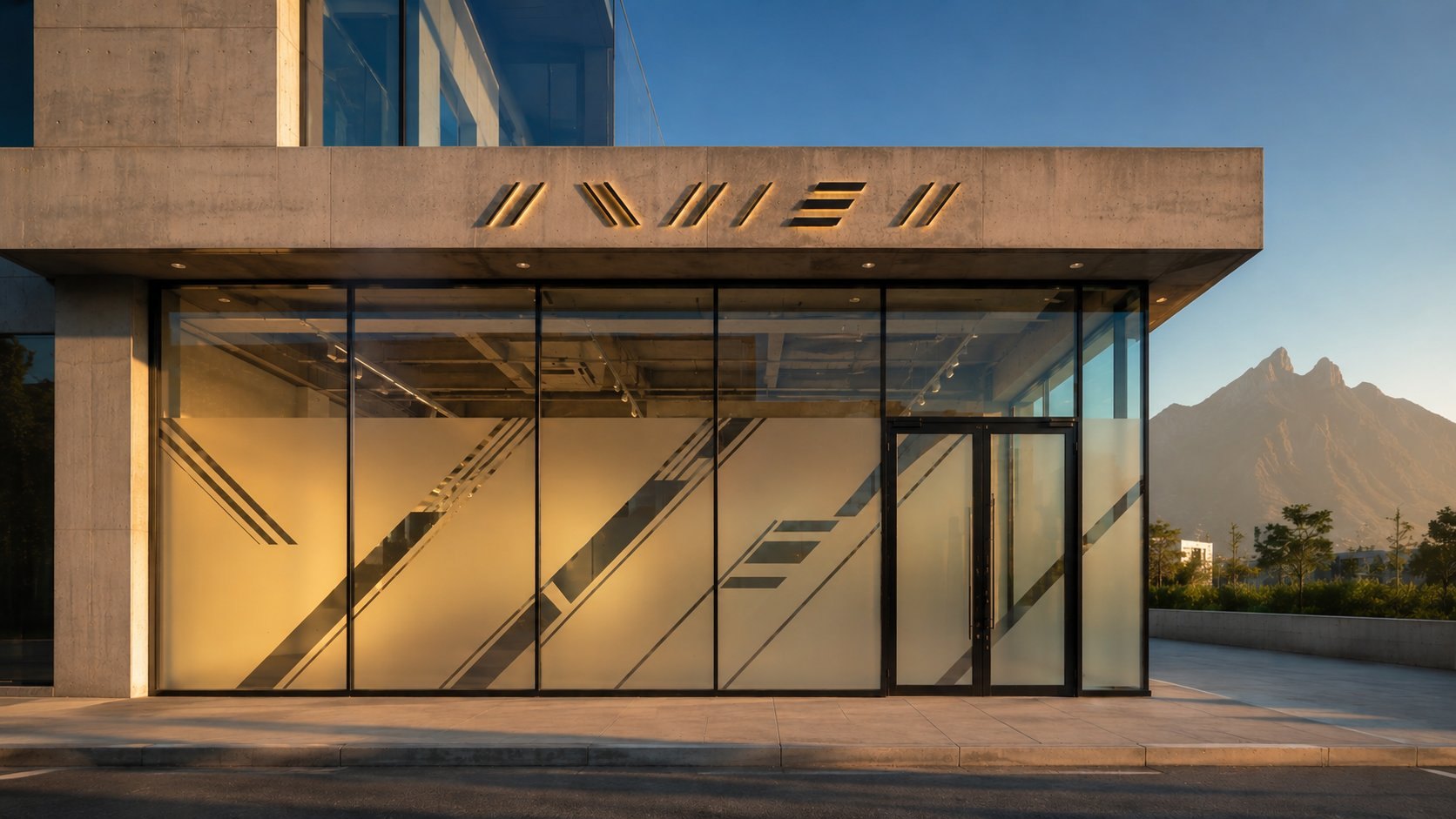 Misma fachada de edificio corporativo en Monterrey después de la instalación de vinil esmerilado con patrón geométrico diagonal y rotulación corporativa por Punto Clave