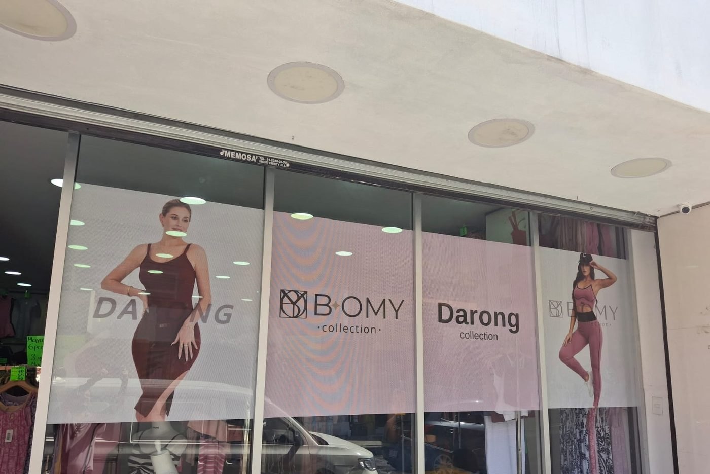 Aparador de tienda de ropa con vinil microperforado impreso a todo color cubriendo los cristales